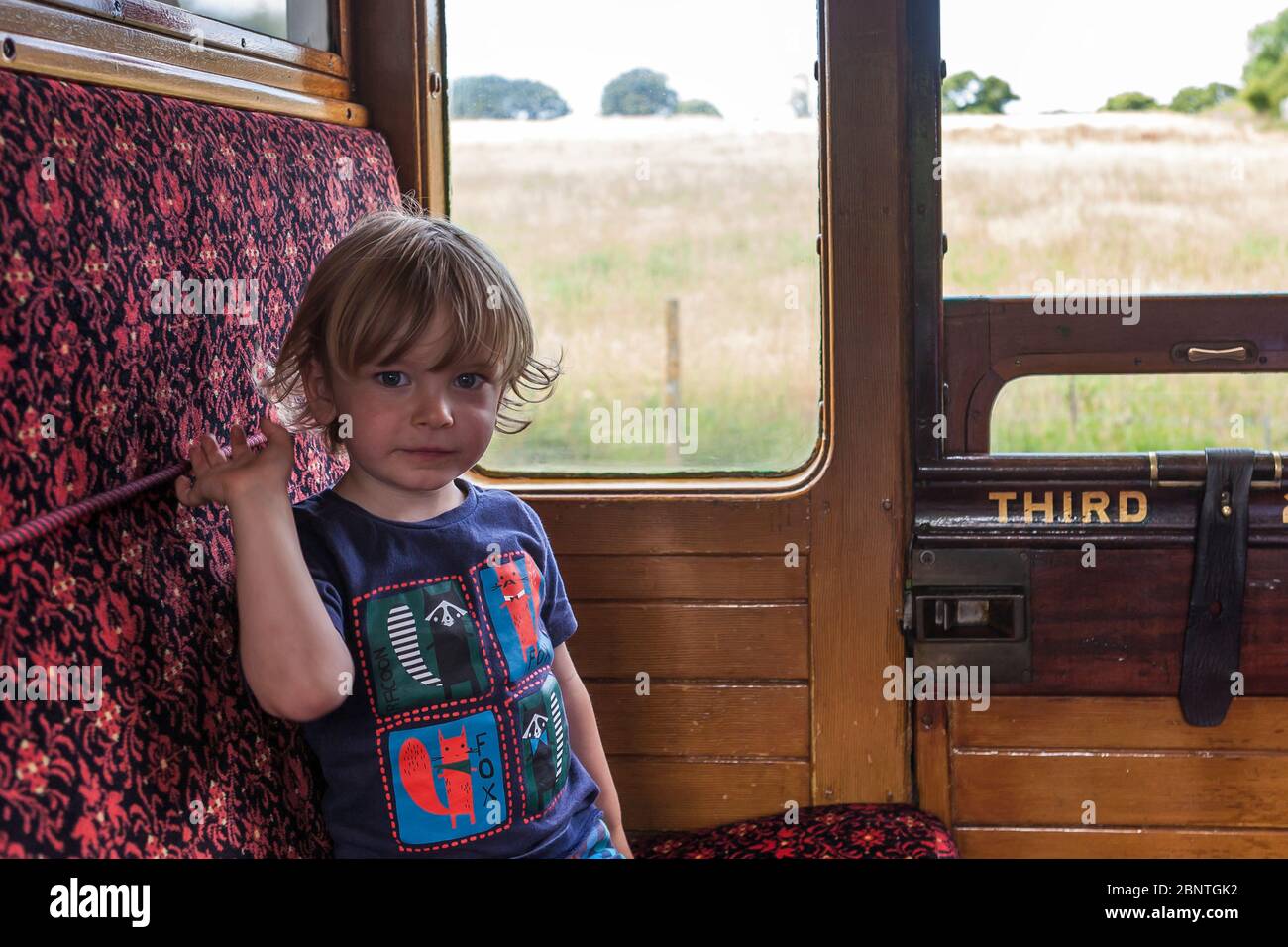 Petit garçon (2/3 ans) qui profite de son trajet sur le chemin de fer à vapeur de l'île de Wight, île de Wight, Royaume-Uni. MODÈLE LIBÉRÉ Banque D'Images