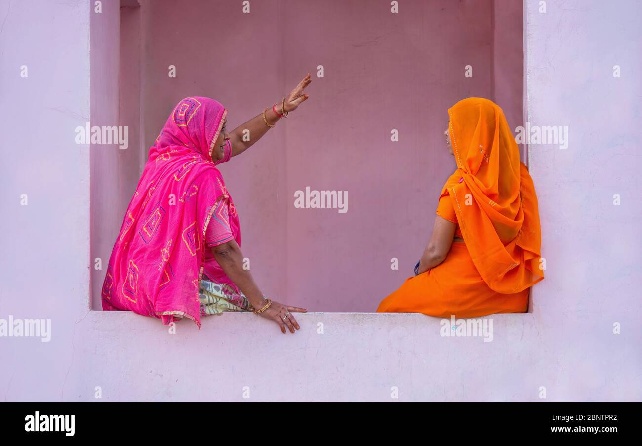 Mandawa, Inde - 17 novembre 2015. Deux indiennes, portant des saris traditionnels aux couleurs vives, ont une conversation à l'extérieur d'un bâtiment de marché. Banque D'Images