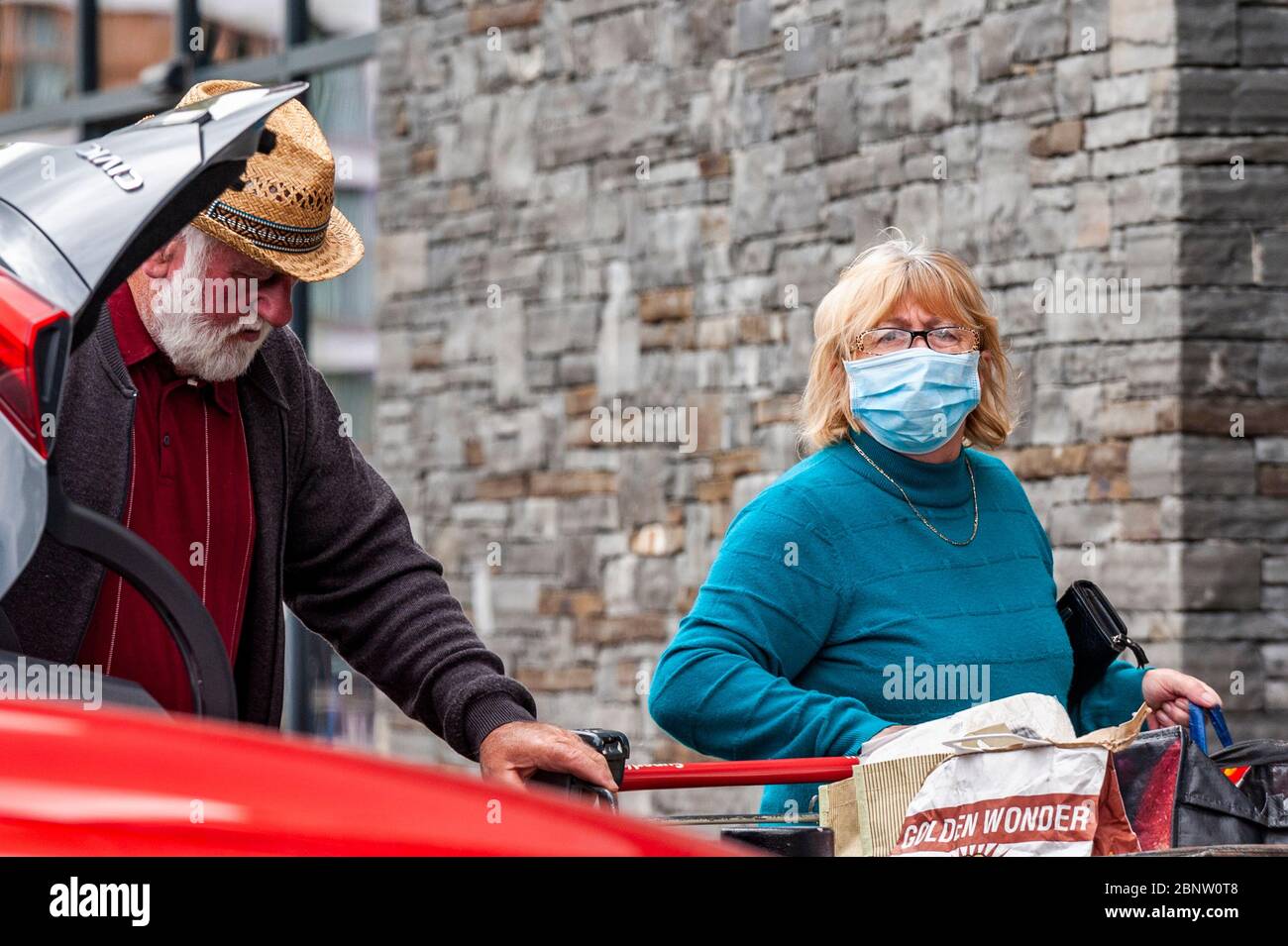 Bantry, West Cork, Irlande. 16 mai 2020. Une femme portant un masque pour se protéger de Covid-19 charge sa voiture après un voyage shopping au supermarché Supervalu à Bantry. Crédit : AG News/Alay Live News Banque D'Images