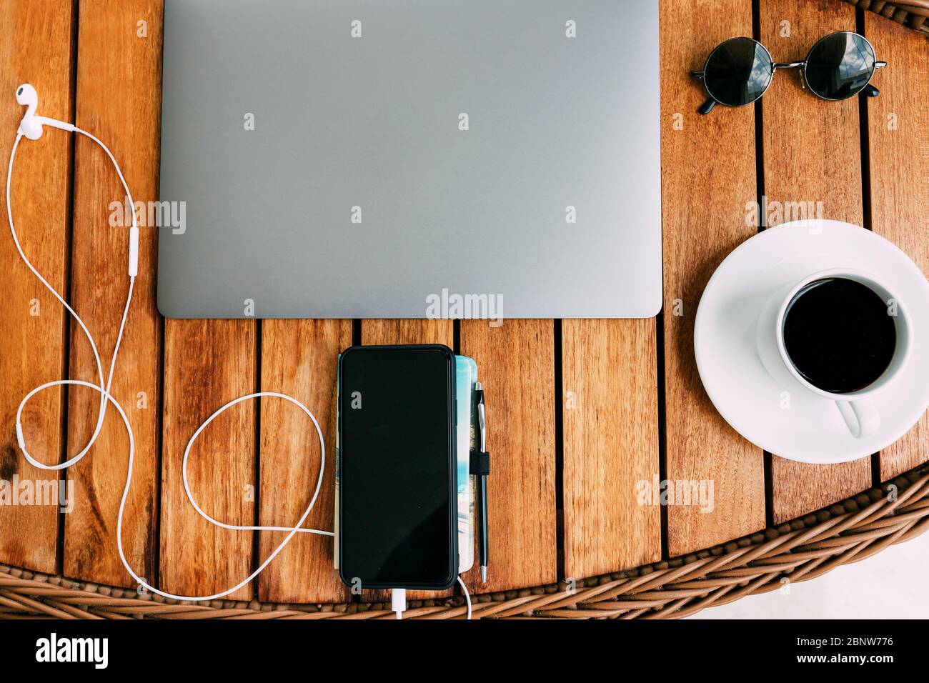 Plan de travail plat pour travailler à un ordinateur portable, une table en bois marron avec une tasse de café et un carnet. Concept freelance. Travail à distance. Copier l'emplacement Banque D'Images