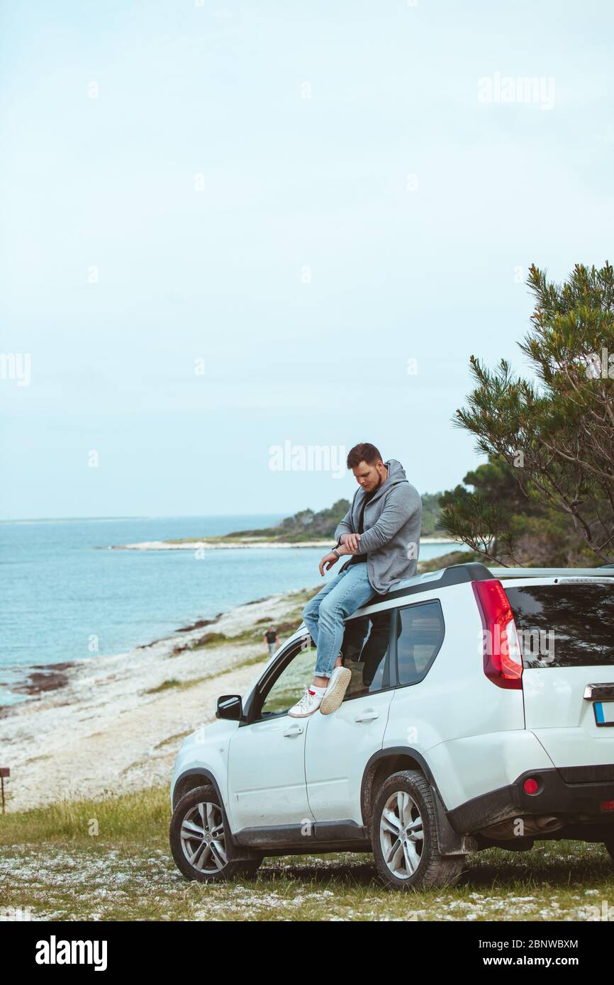 Heureux homme assis sur le toit d'une voiture Banque de photographies ...