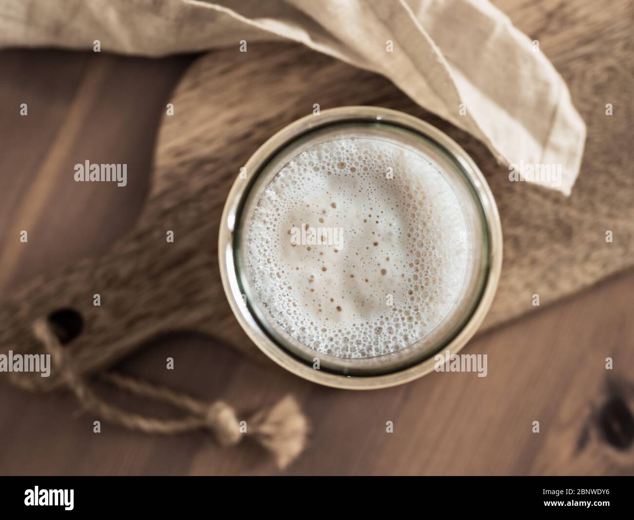 Démarreur de levain de blé. Vue de dessus du bol en verre avec démarreur à la pâte sur planche à découper en bois. Copier l'espace pour le texte ou la conception. Banque D'Images