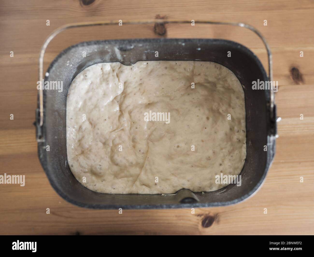 Levain de blé dans un moule à pain de machine à pain sur table en bois. Concept de pain maison. Vue de dessus ou plan d'étapage Banque D'Images