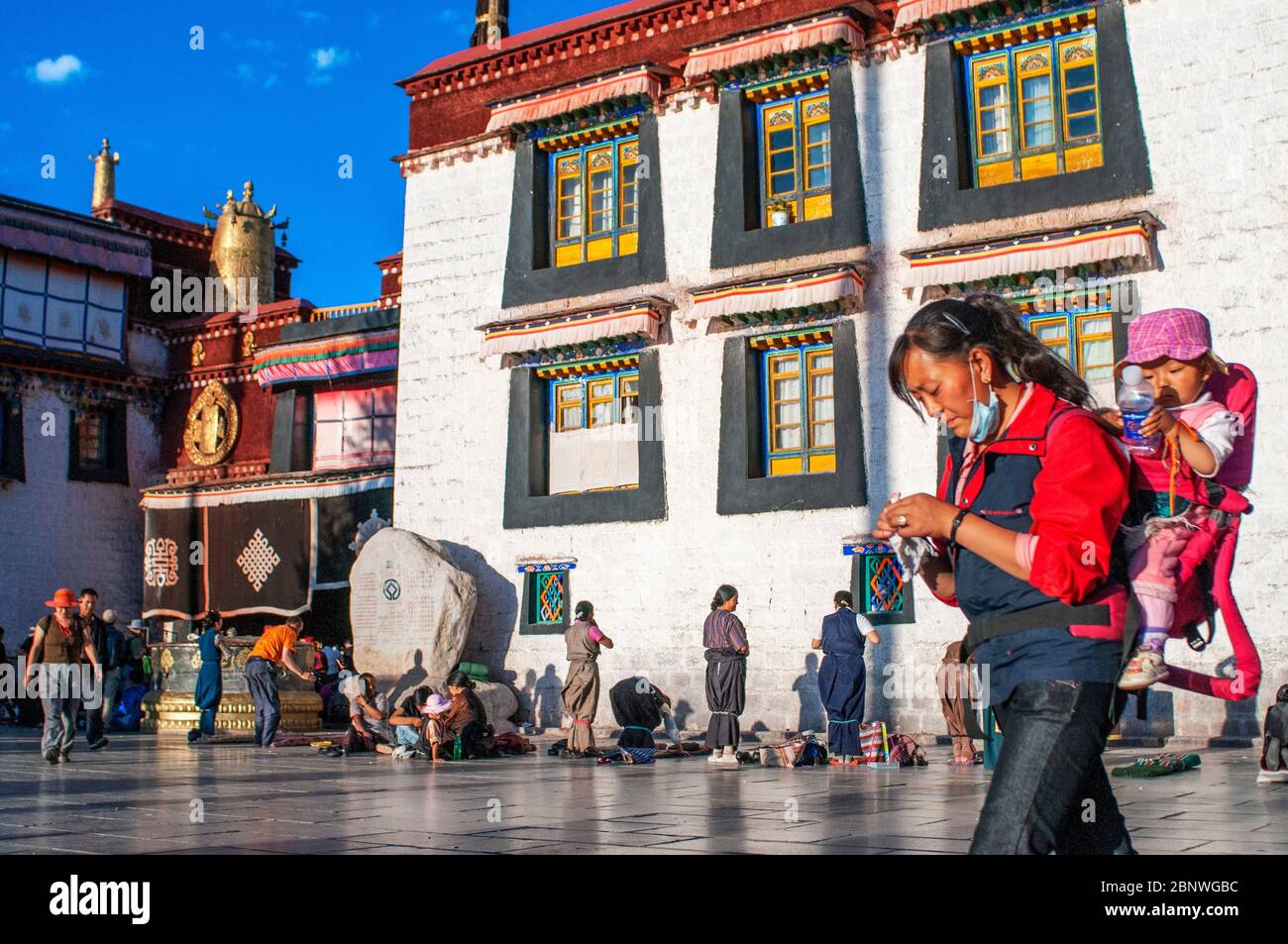 Mère avec bébé consacrer faire la Kora dans le sens des aiguilles d'une montre cirambulation autour du temple de Jokhang, Lhassa Tibet. Place Barkhor au coeur de la vieille ville de Lhassa à Ti Banque D'Images