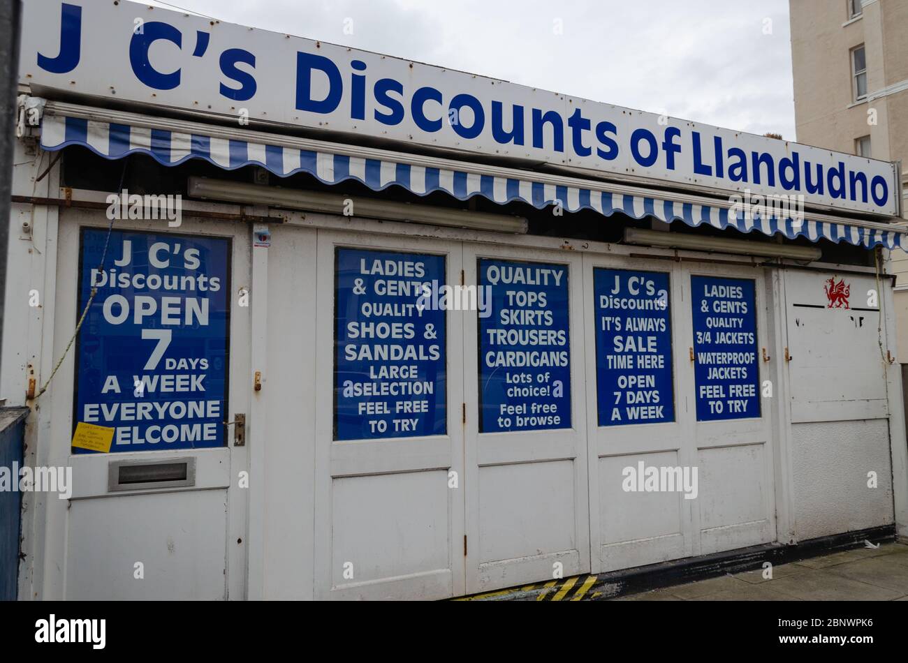 Llandudno, Royaume-Uni: 27 août 2019: J C's Promotions de Clonmel Street sont des détaillants de vêtements qui ouvrent 7 jours par semaine. Vu ici en dehors des heures d'ouverture. Banque D'Images