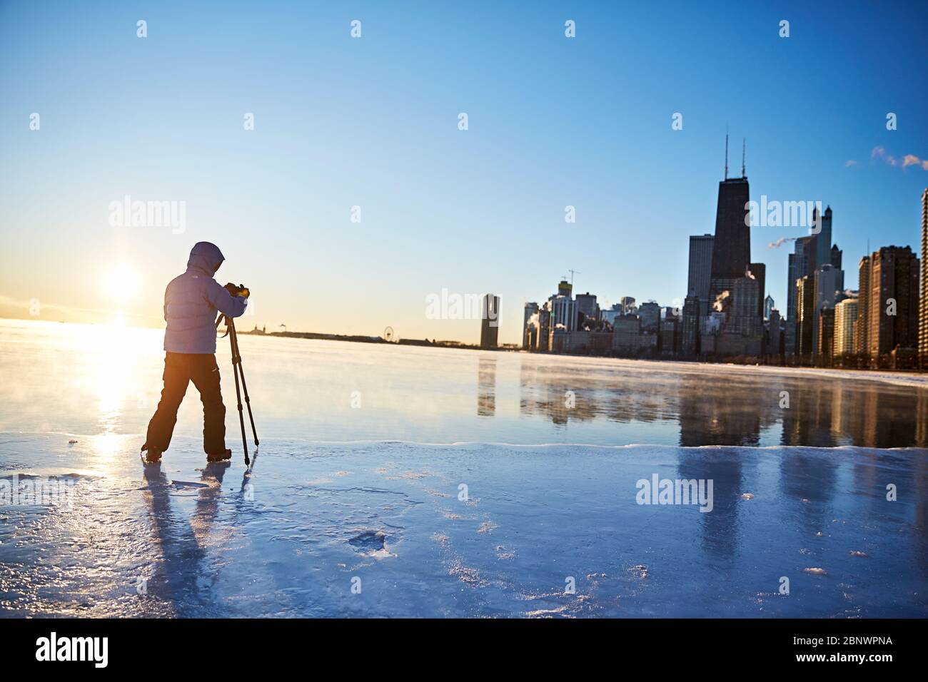 Un photographe aventureux installe l'appareil photo sur un emplacement audacieux sur la glace pour prendre la photo Banque D'Images