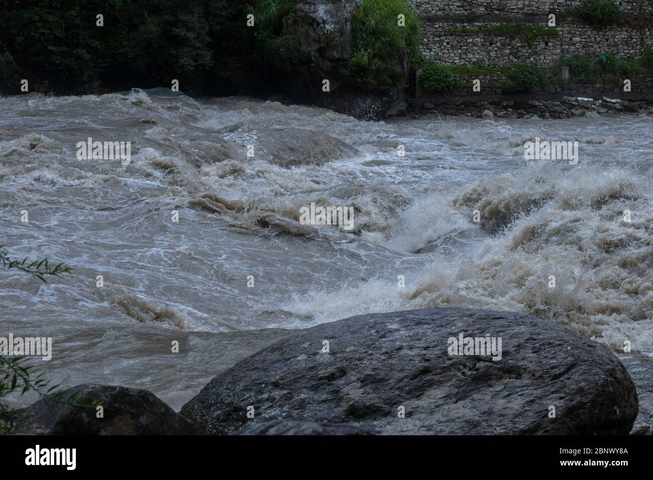 Une des vagues de la rivière Parvati qui se heurtent de façon spectaculaire après une énorme tempête qui a fait tourner l'eau boueuse, 5K Banque D'Images