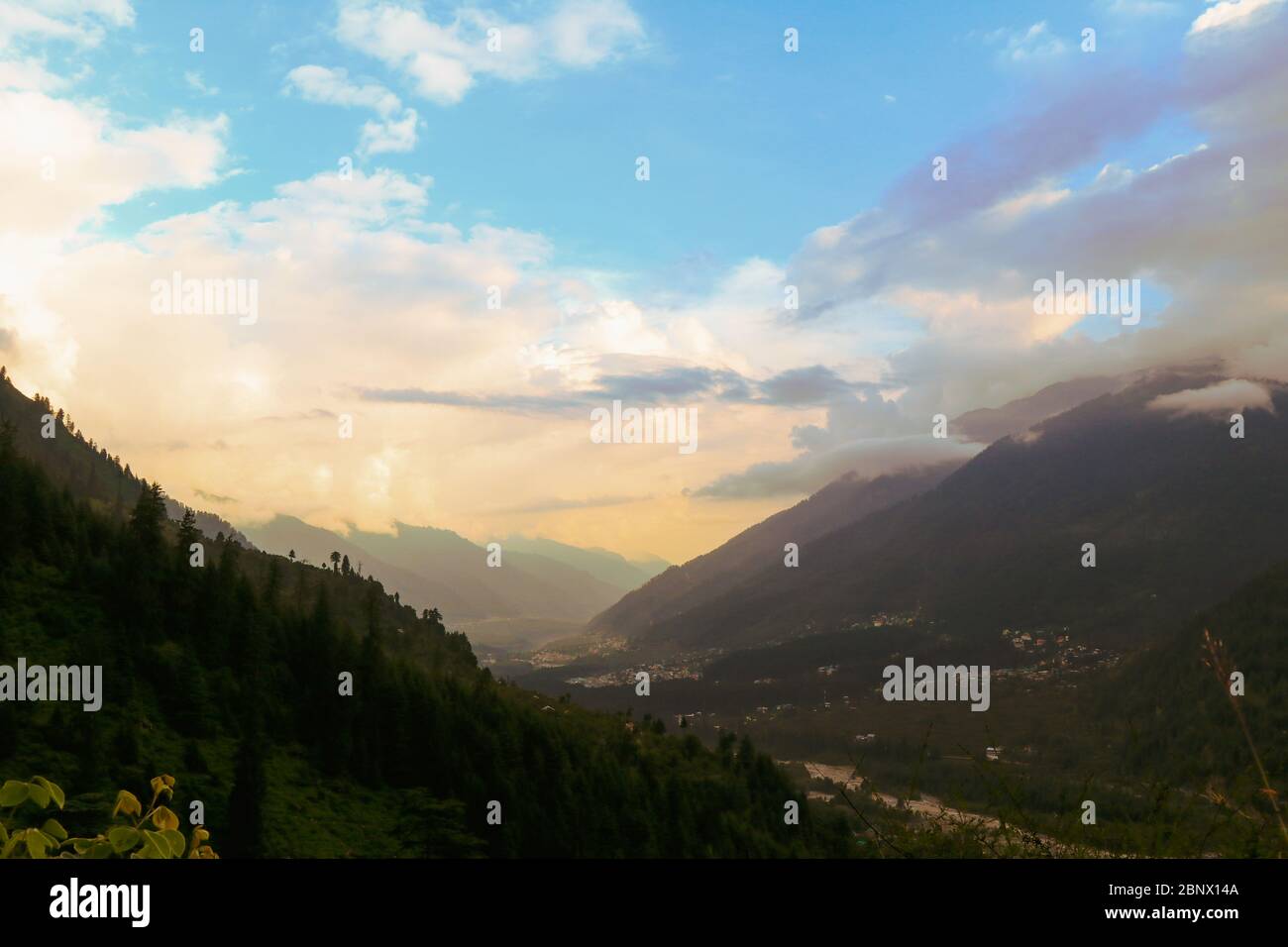 Paysage, Manali City au coucher du soleil affiche un jeu exotique de lumière, de couleurs et de nuages. La rivière Vyas coule transportant des eaux boueuses de la pluie, 5K Banque D'Images