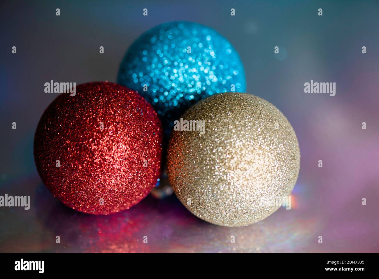 Trois boules étincelantes sur fond holographique. Banque D'Images