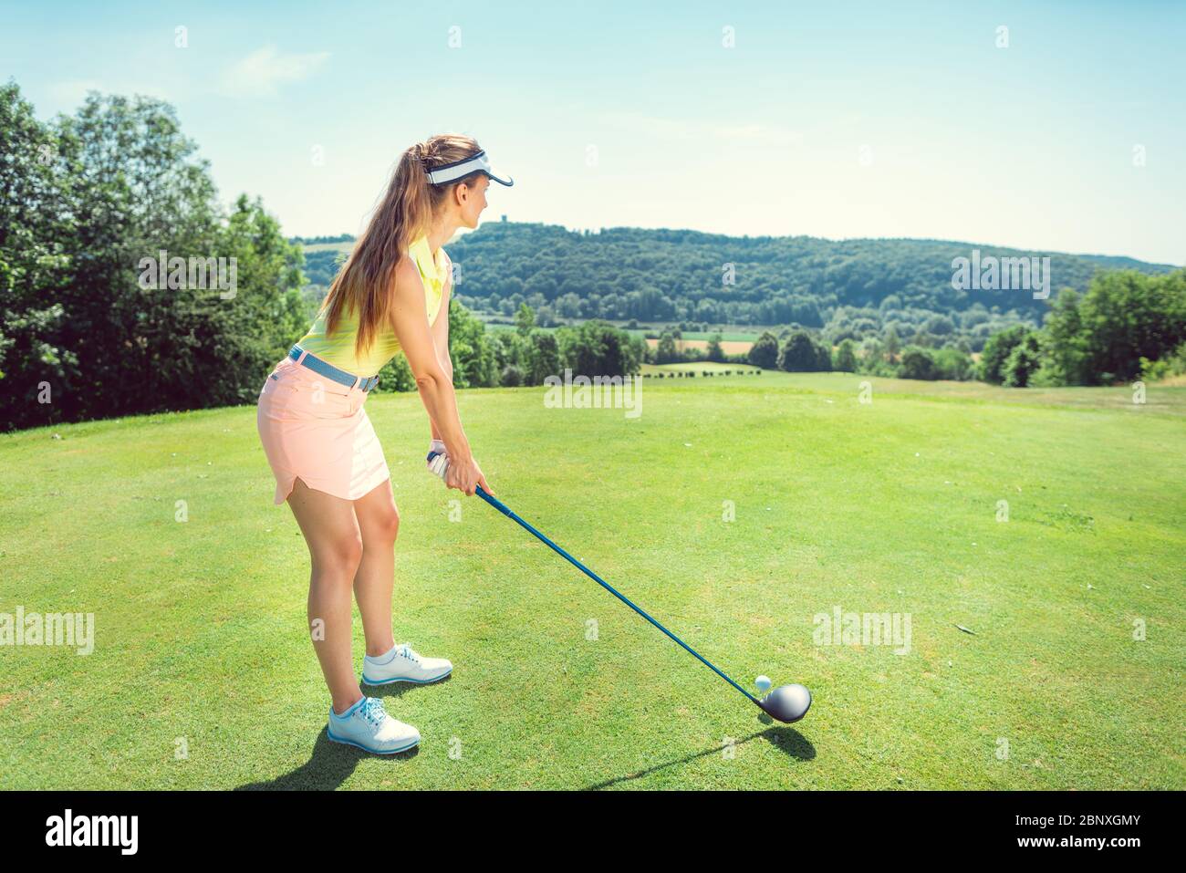 Belle femme jouant au golf sur un terrain ouvert Banque D'Images