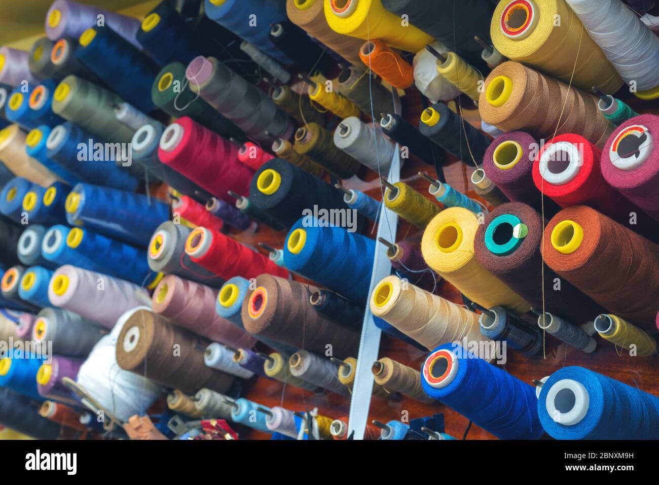 Fil de couleur sur bobines dans un atelier de couture. Concept de l'industrie du vêtement Banque D'Images