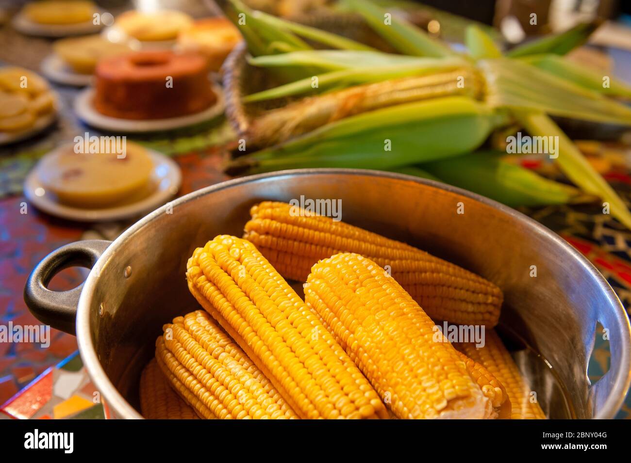 Table avec les aliments traditionnels des festivals de juin dans le nord-est du Brésil, avec un accent sur le maïs bouilli. Banque D'Images