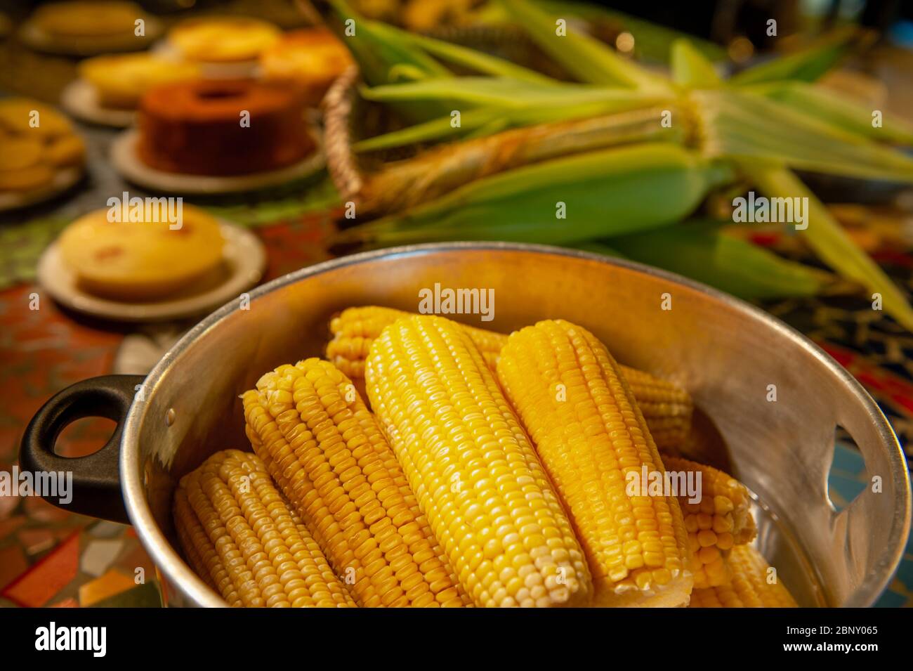 Table avec les aliments traditionnels des festivals de juin dans le nord-est du Brésil, avec un accent sur le maïs bouilli. Banque D'Images