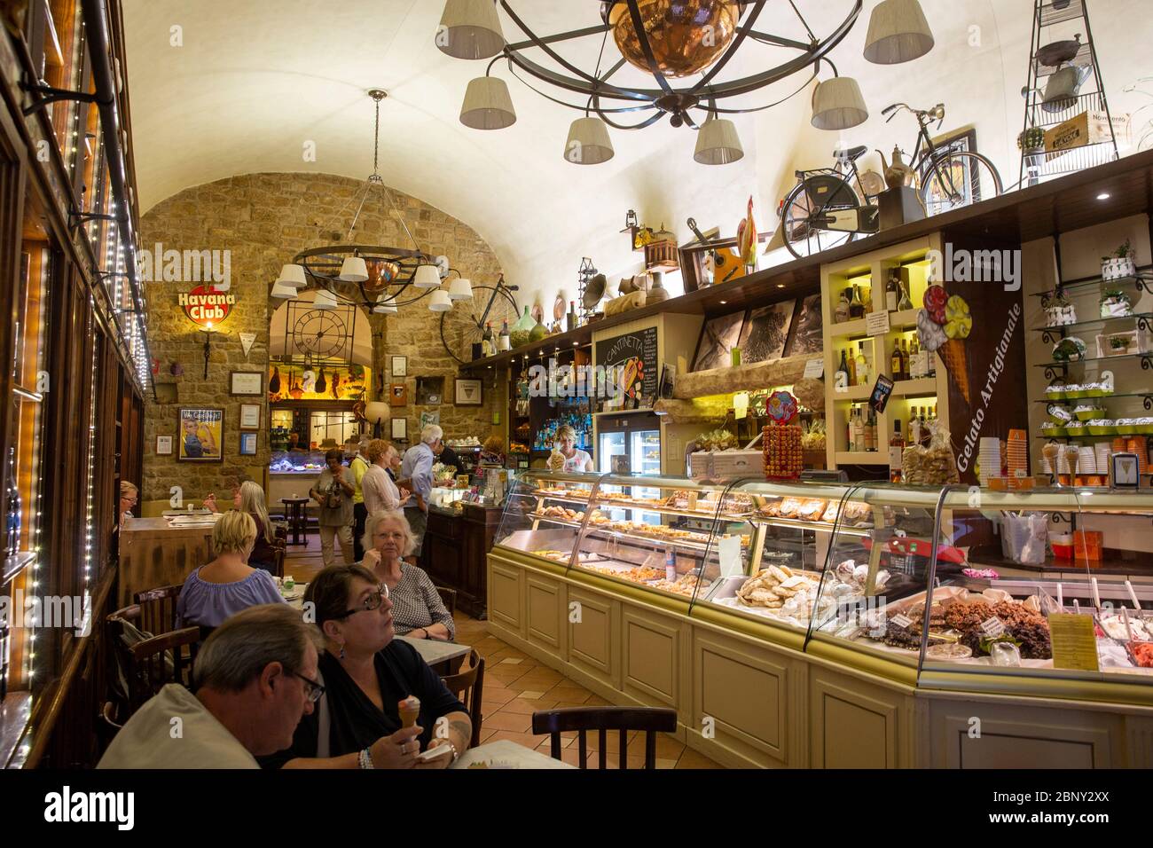 Intérieur traditionnel de café italien dans la ville médiévale de Volterra avec glace et gâteau servi, Toscane, Italie Banque D'Images