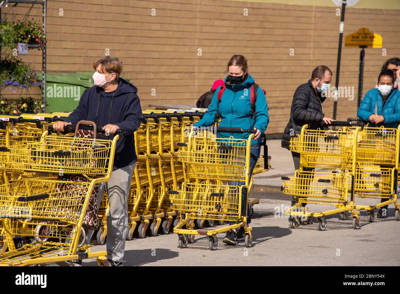 Montréal, CA - 16 mai 2020 : clients d'une ligne à l'extérieur d'un supermarché. Certains portent des masques de protection Covid-19. Banque D'Images