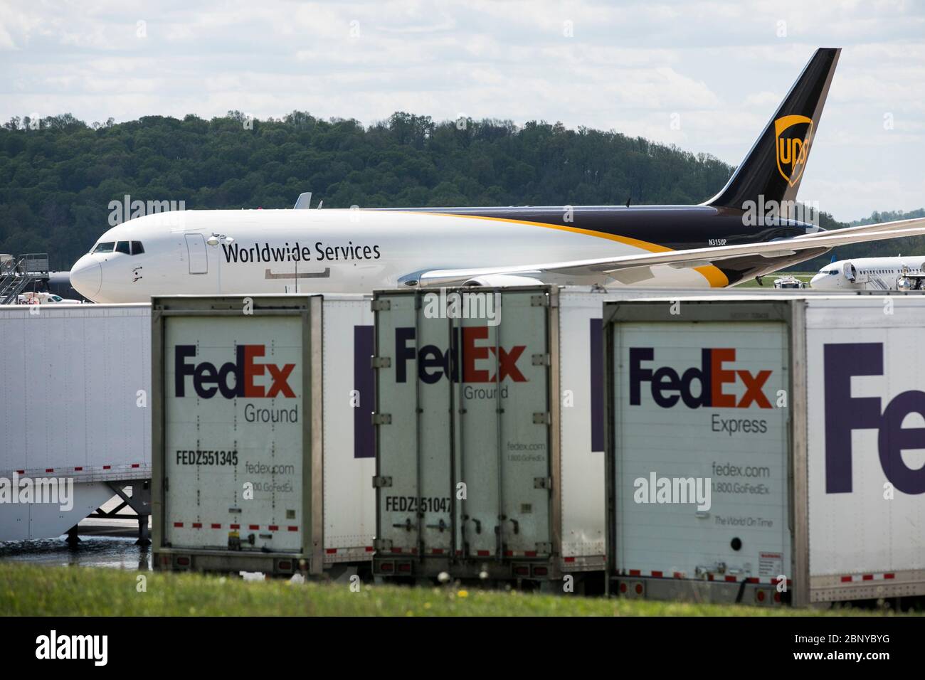 Les remorques de camions FedEx Express sont visibles devant un avion UPS United Parcel Service à Middletown, en Pennsylvanie, le 4 mai 2020. Banque D'Images