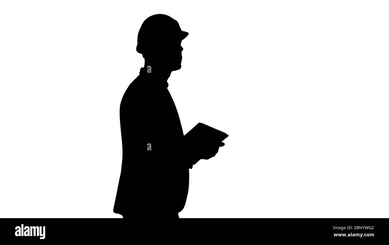 Silhouette Architect se promenant avec une tablette et vérifiant ce qui est construit. Banque D'Images