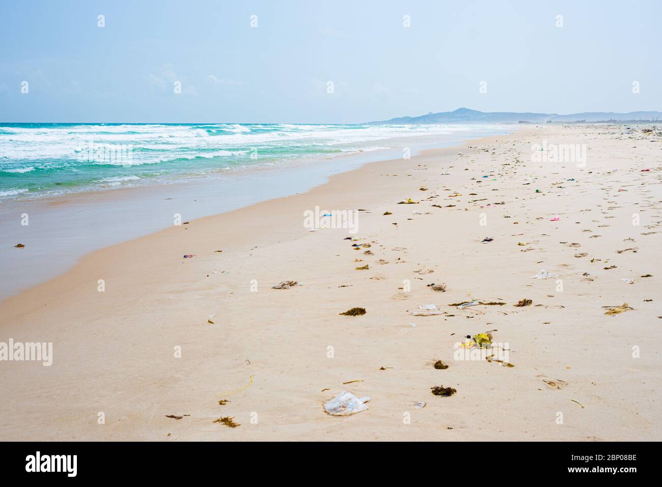 Vider la plage tropicale avec les déchets de plastique sur le sable ...
