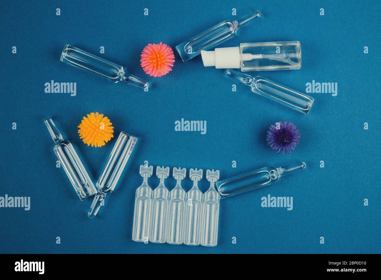 Modèle abstrait du coronavirus, ampoule avec médicament et flacon avec gel antibactérien pour les mains sur fond bleu contre le coronavirus. Banque D'Images