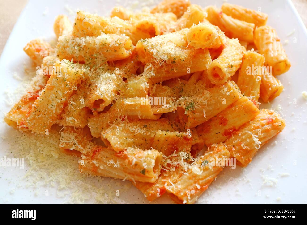 Gros plan sur des pâtes rigatoni crémeuses et savoureuses avec de la sauce tomate au parmesan Banque D'Images