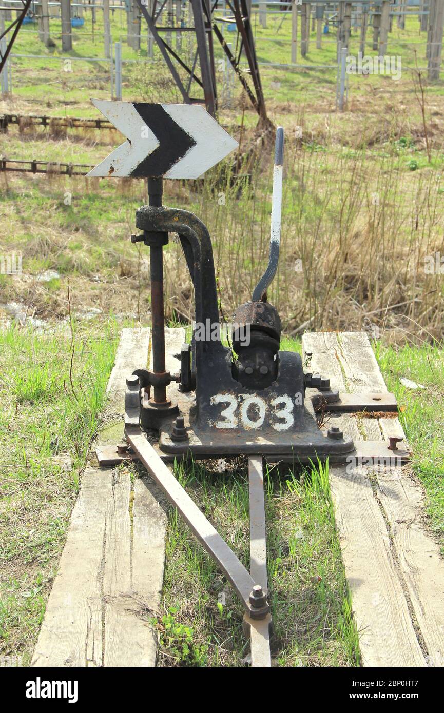 Flèche de chemin de fer en noir avec un levier et un pointeur en Russie. Dispositif de transfert de rails aux intersections pour les trains. Élément technique de l'industrie ferroviaire. Banque D'Images
