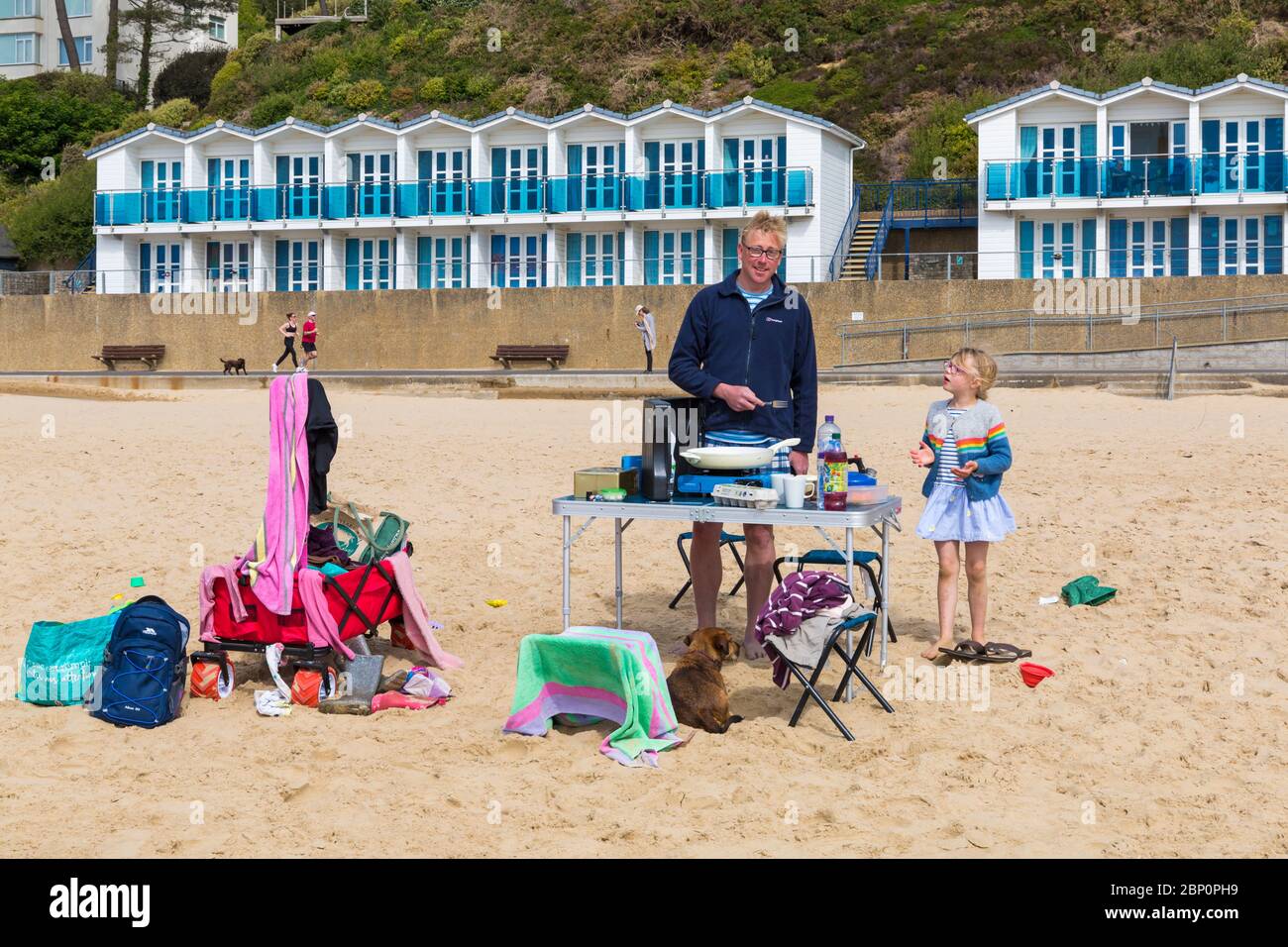 Poole, Dorset Royaume-Uni. 17 mai 2020. Météo au Royaume-Uni : Les plages de Poole sont chaudes et ensoleillées, tandis que les amateurs de plage se dirigent vers la mer pour profiter du soleil le premier week-end après les changements pour atténuer les restrictions du coronavirus qui permettent aux gens de s'asseoir ou de prendre le soleil sur la plage autant qu'ils le souhaitent tant qu'ils adhèrent à la distanciation sociale. Temps pour le petit déjeuner - Gareth prépare le petit déjeuner sur la plage. Crédit : Carolyn Jenkins/Alay Live News Banque D'Images