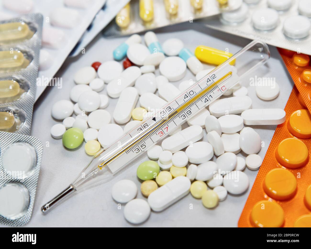 Thermomètre médical en verre sur fond de médicaments. Banque D'Images