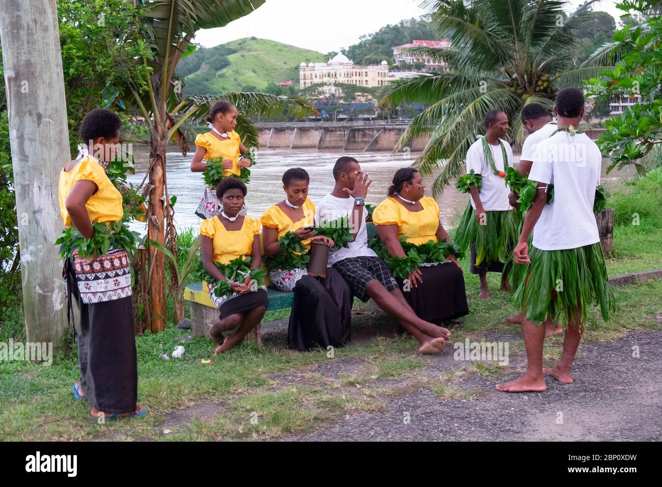 Des hommes et des femmes vêtus pour une cérémonie traditionnelle attendent près du fleuve à Sigatoka (Singatoka), Fidji Banque D'Images