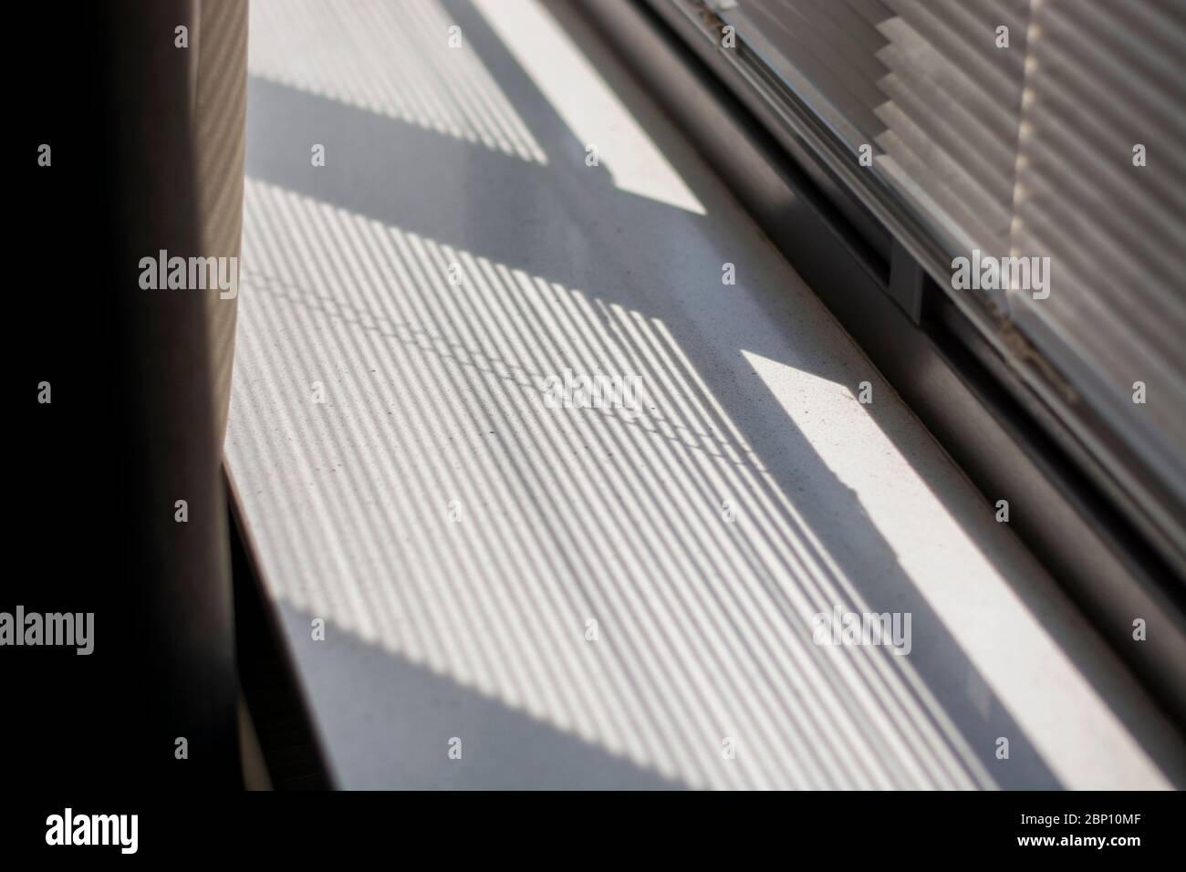 Ombre et lumière à travers la fenêtre des stores sur le seuil de la fenêtre. Lumière et ombre du matin. Rideau sur la gauche. Banque D'Images