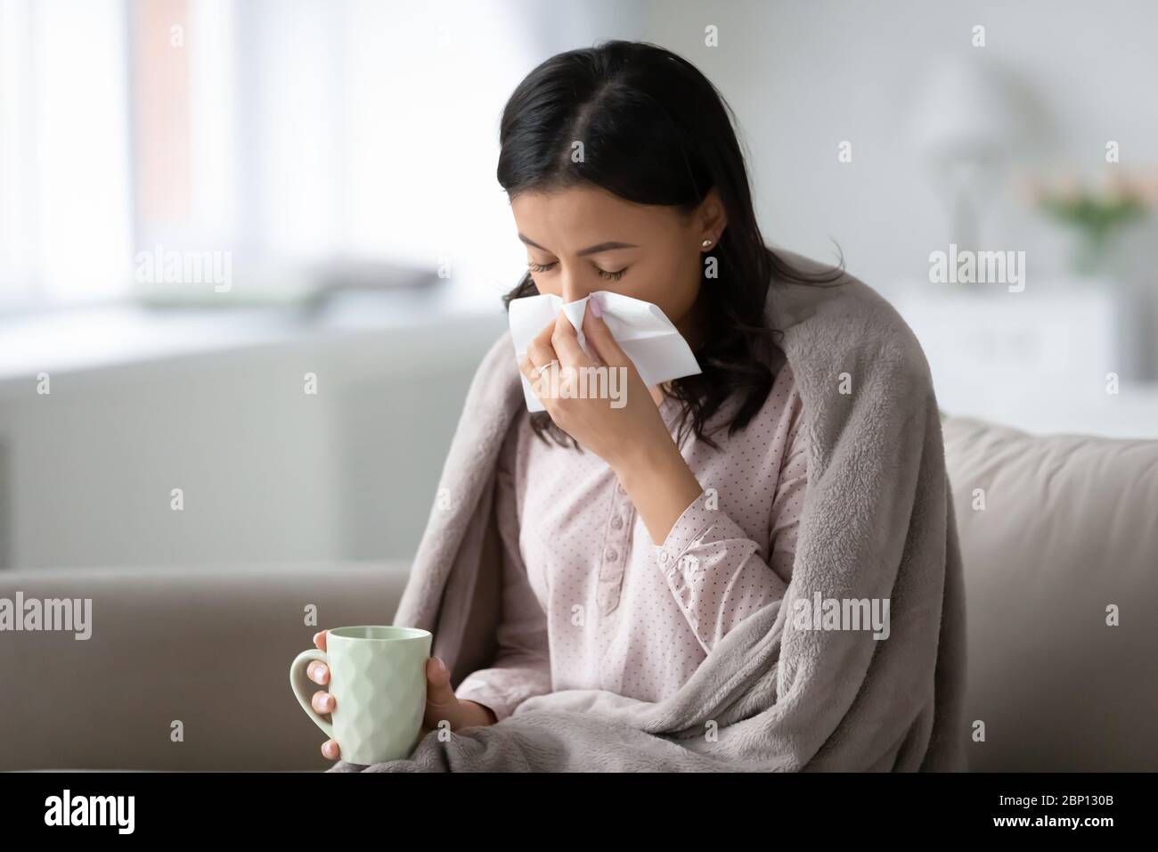 Femme africaine buvant remède froid souffle nez liquide utiliser des tissus Banque D'Images