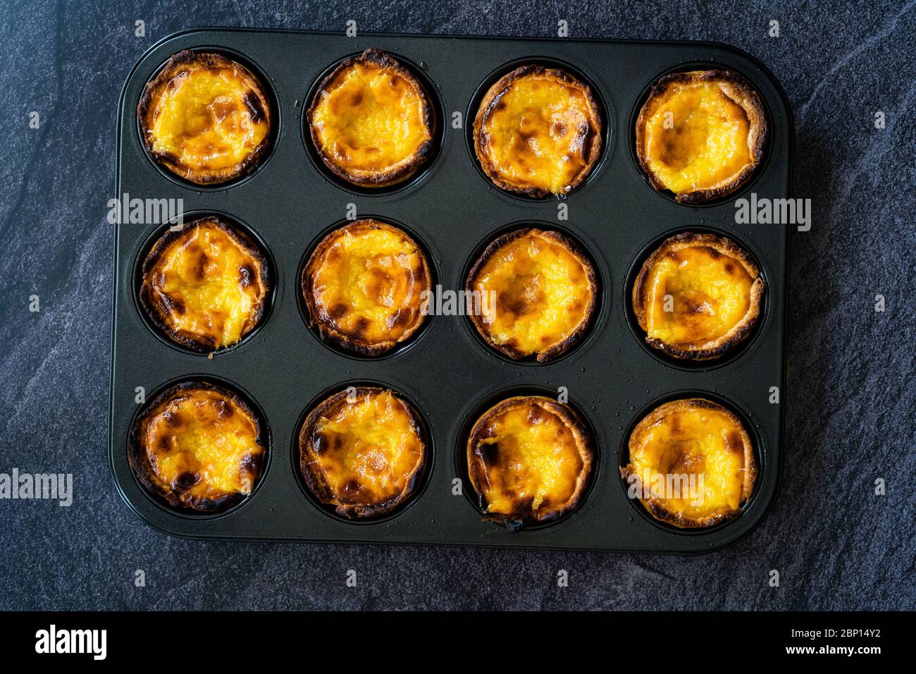 Pasteiis de Nata ou Belem Tart. Custard portugais fait avec des œufs, de la cannelle, du sucre et de la farine dans un moule à muffins/gâteau. Dessert traditionnel. Banque D'Images