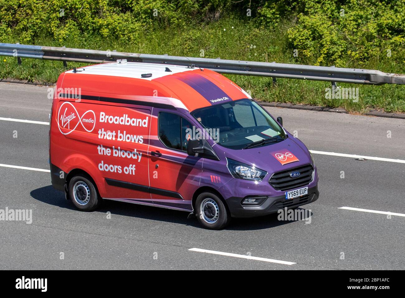 Virgin Media Broadband service ' qui souffle les portes sanglantes hors de Ford Transit Custom 300Leader véhicule; véhicule de circulation en mouvement, conduite de véhicule sur les routes britanniques, les moteurs, les fourgonnettes d'affaires sur l'autoroute M6 Banque D'Images