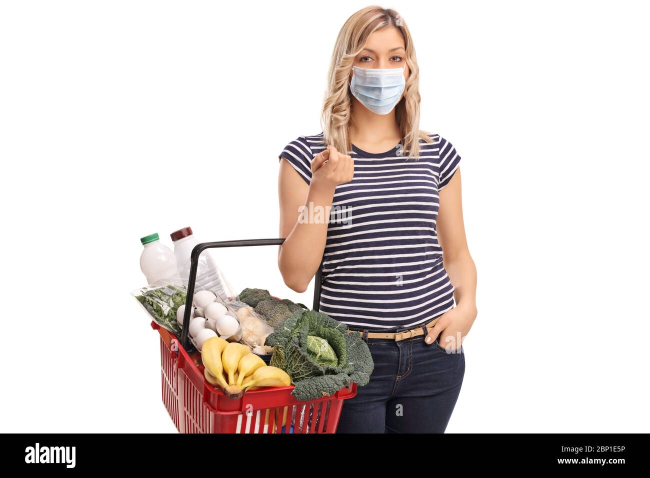 Jeune femme portant un masque facial de protection et portant un panier isolé sur fond blanc Banque D'Images