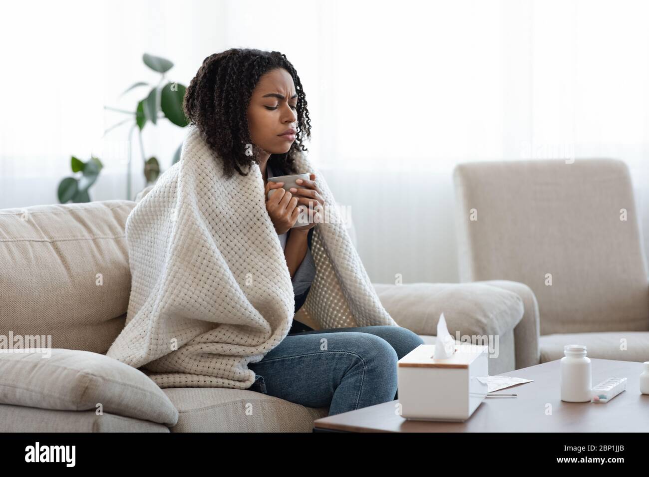 Malade Femme noire souffrant de la grippe à la maison, boire du thé et se reposer Banque D'Images