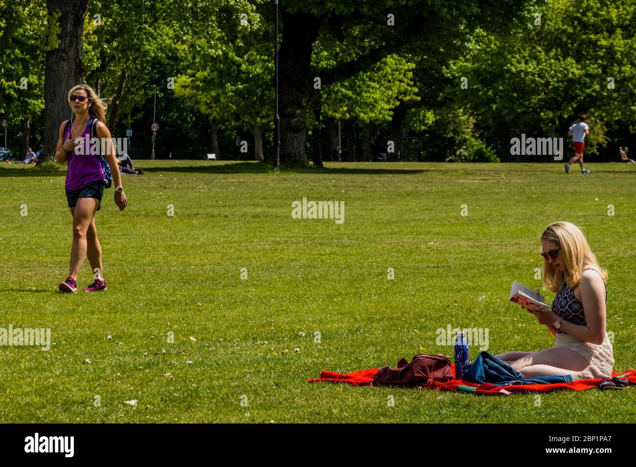 Londres, Royaume-Uni. 17 mai 2020. Une femme combine le soleil et commence à lire « tuer un oiseau moqueuse », par Harper Lee, au soleil à Spencer Park, Wandsworth, alors que le coronavirus Lockdown est assoupli. Le premier week-end suivant l'assouplissement du « verrouillage » de l'épidémie du coronavirus (Covid 19) à Londres. Crédit : Guy Bell/Alay Live News Banque D'Images