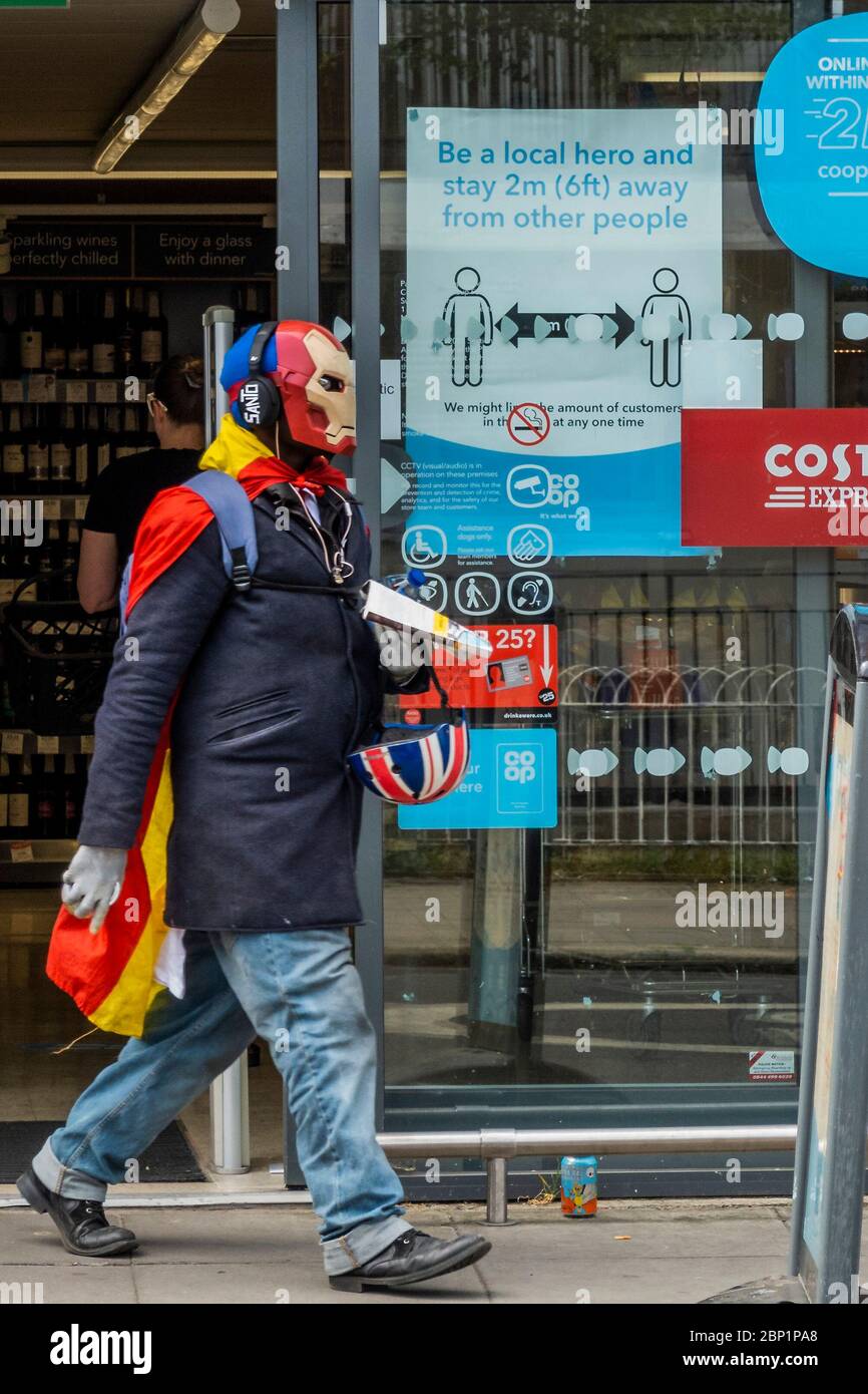 Londres, Royaume-Uni. 17 mai 2020. Un homme dans un masque d'homme de fer fait la queue et fait ensuite des courses au CO-OP de Teh Munster Road - où tout le monde est un « héros local » s'ils restent à 2 m des autres. Le « verrouillage » se poursuit pour l'épidémie du coronavirus (Covid 19) à Londres. Crédit : Guy Bell/Alay Live News Banque D'Images