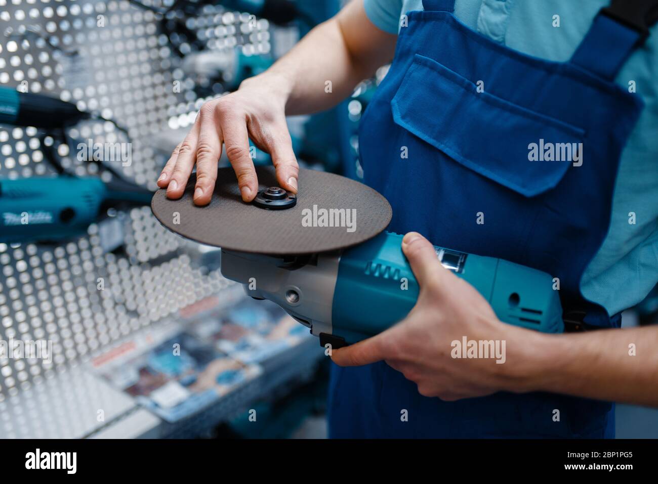Un ouvrier choisit un disque à bords tranchants dans le magasin d'outils Banque D'Images