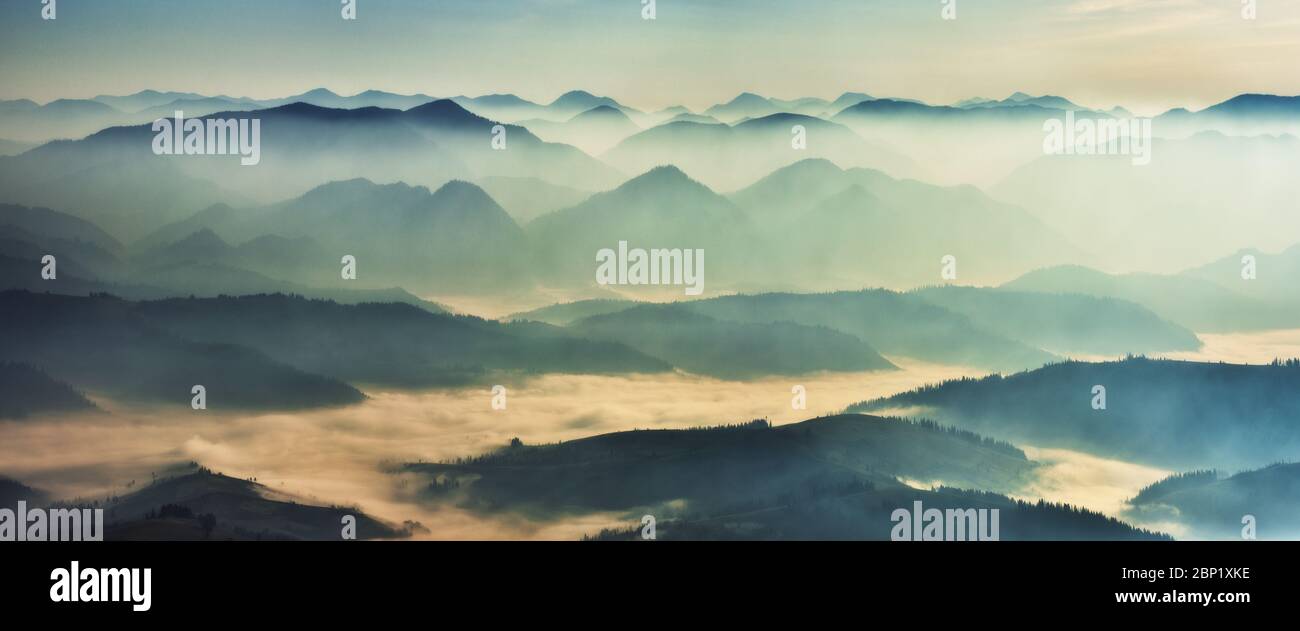 Avant l'aube dans les hauts plateaux, silhouettes de montagne dans le brouillard Banque D'Images