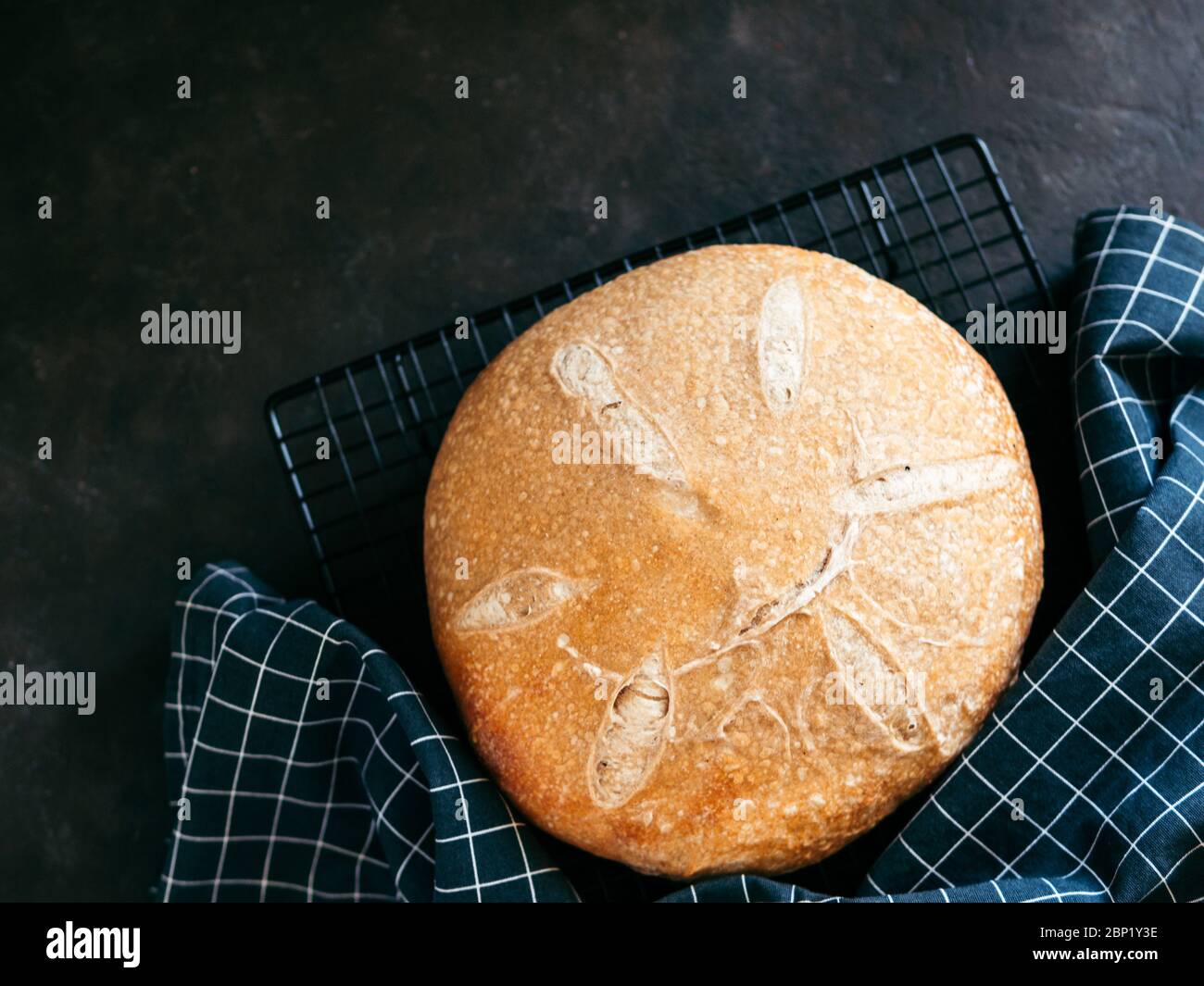 Pain de levain rond de blé. Vue de dessus de délicieux pain de levain maison sur fond noir avec espace de copie. Concept de fabrication de pain au levain fait maison. Banque D'Images