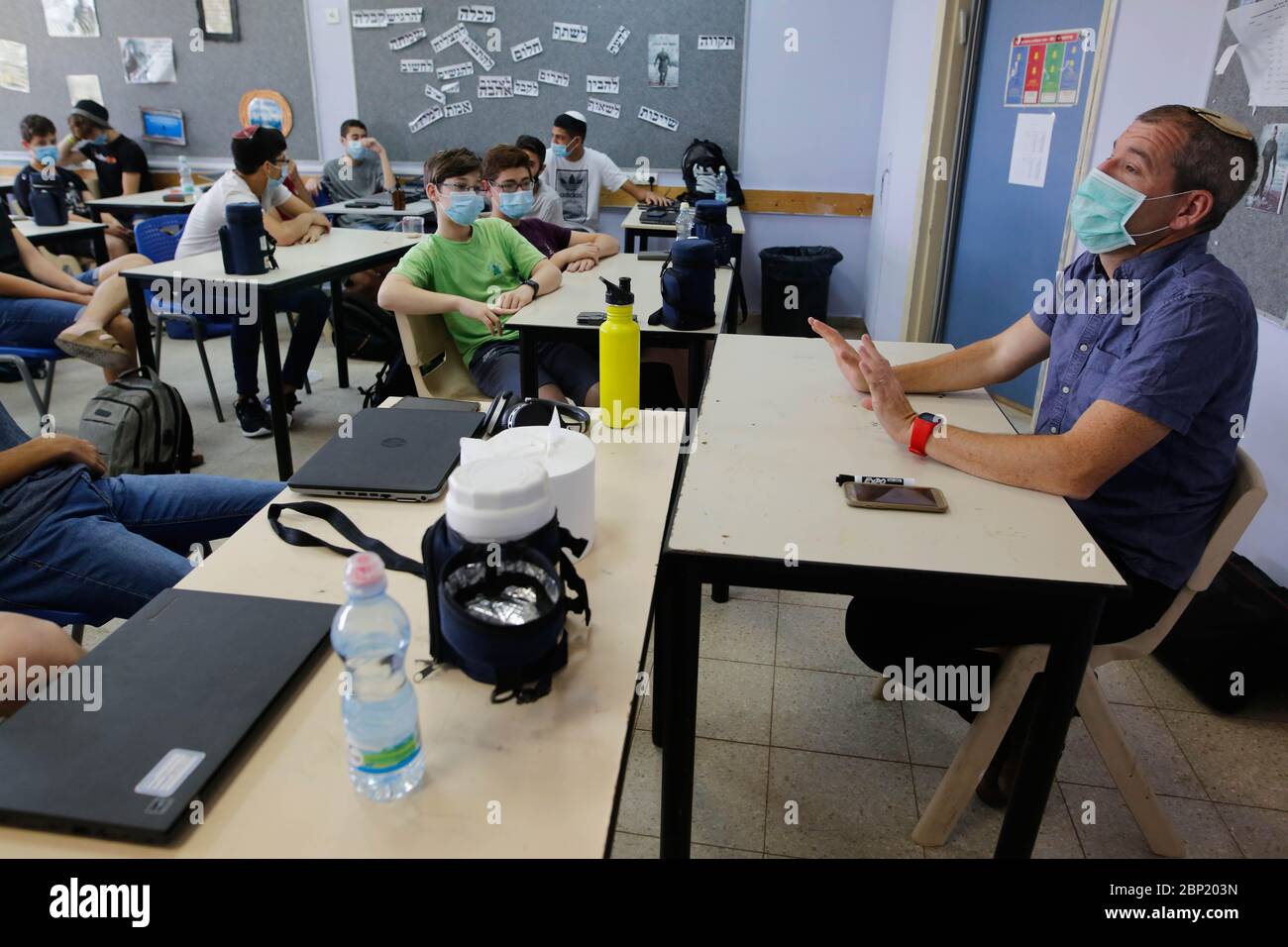 Modifier. 17 mai 2020. Un professeur portant un masque donne une leçon aux élèves d'une salle de classe dans la ville israélienne centrale de Modiin, dans le contexte de la pandémie COVID-19, le 17 mai 2020. Les étudiants israéliens de toutes les classes sont revenus à l'école dimanche. Crédit: Gil Cohen Magen/Xinhua/Alay Live News Banque D'Images