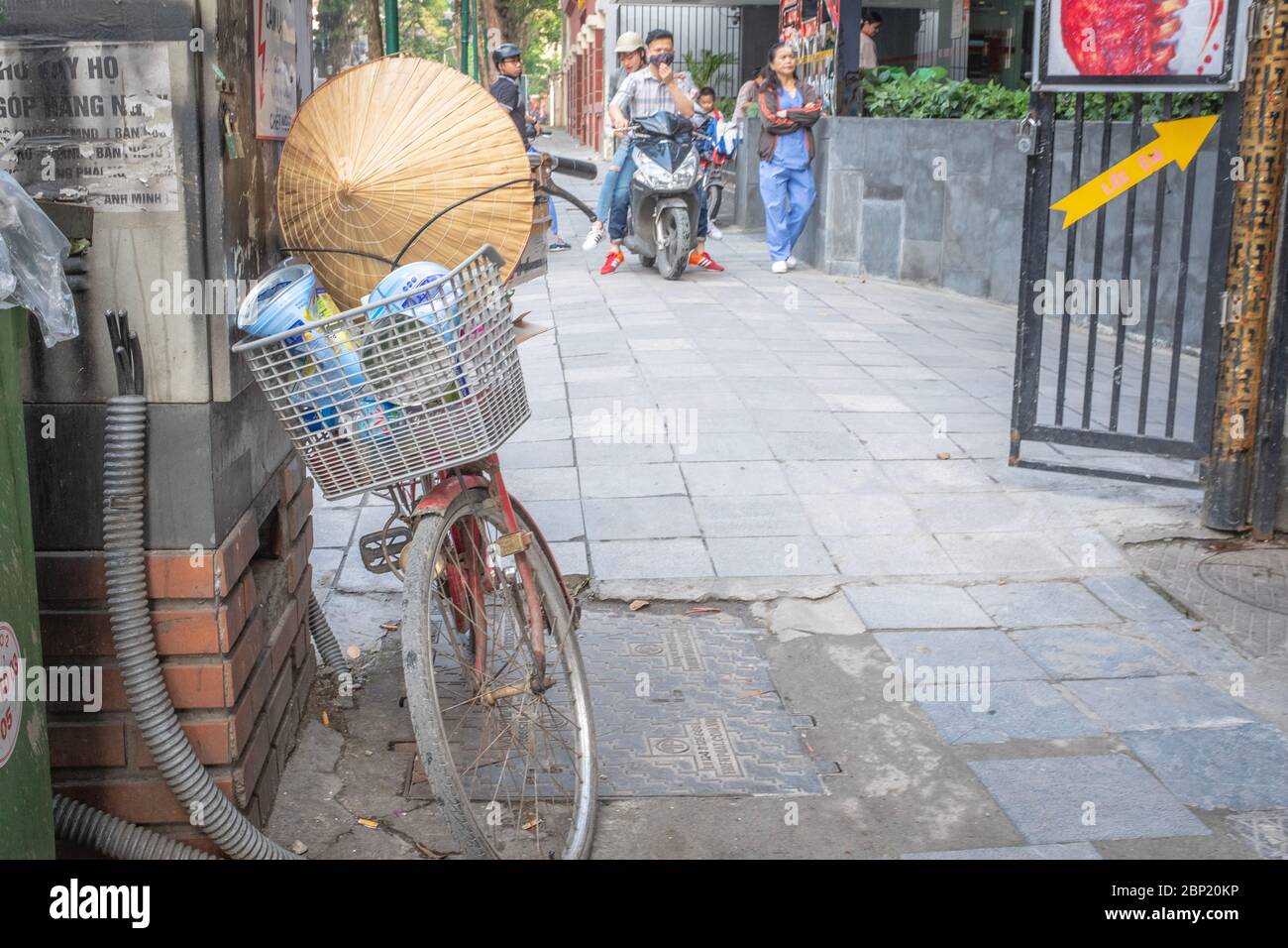 Hanoï, Vietnam - 28 avril 2018 : scène de rue avec chapeau de paille, bicyclettes et quelques personnes en arrière-plan Banque D'Images