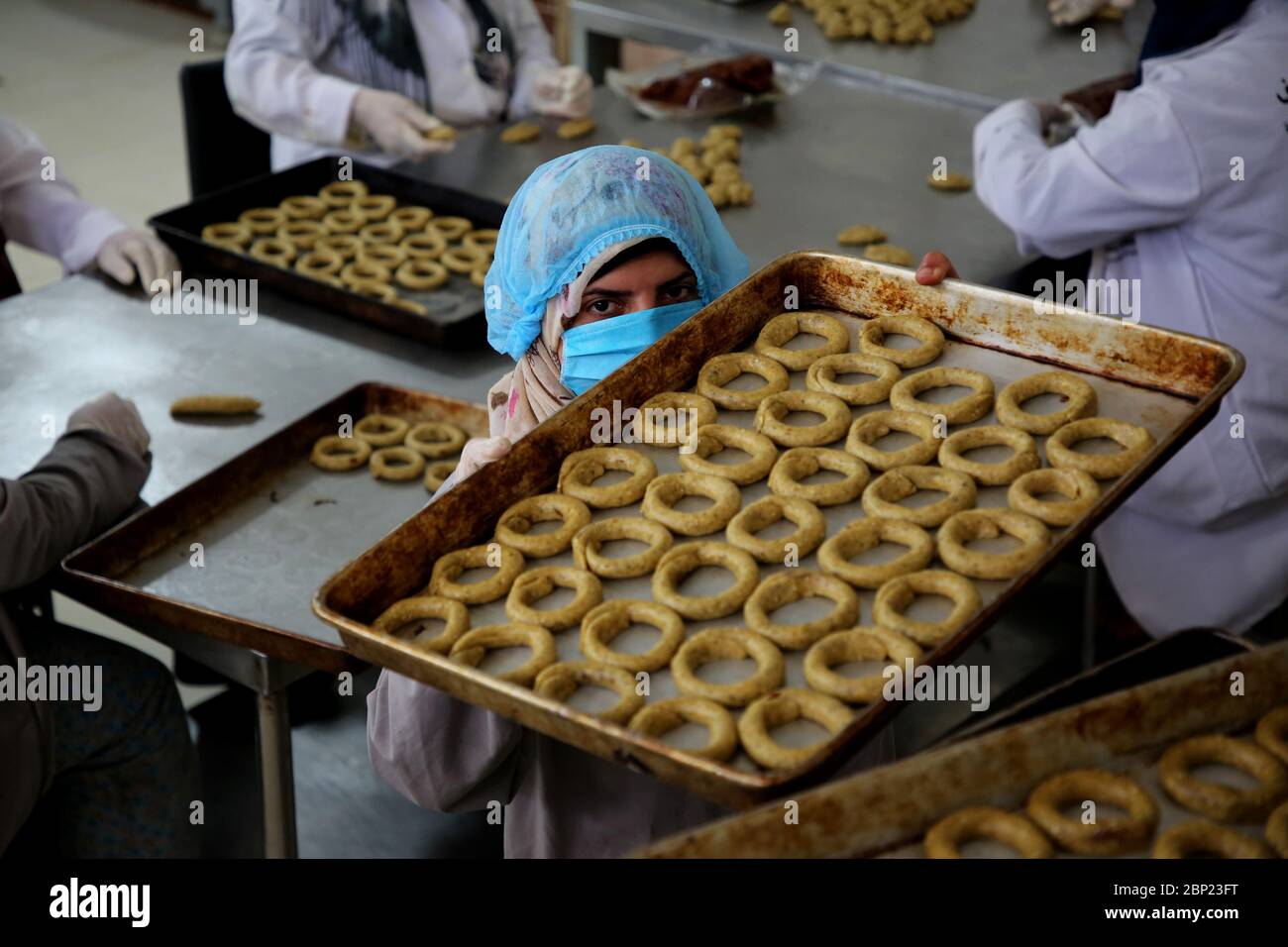 Gaza. 17 mai 2020. Les femmes palestiniennes préparent des biscuits traditionnels à la vente dans une association de femmes locale avant le festival d'Eid al-Fitr pour célébrer la fin du mois Saint du Ramadan, pendant le confinement dû à l'épidémie de COVID-19, dans la ville de Beit Lahia, dans le nord de la bande de Gaza, le 17 mai 2020. Crédit: Rizek Abdeljawad/Xinhua/Alamy Live News Banque D'Images