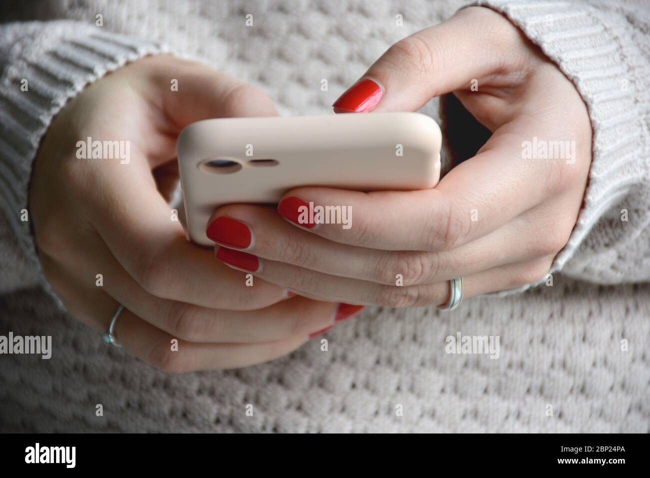 Gros plan femme avec ongles rouges à l'aide de son téléphone portable. Envoi d'un message avec un smartphone. Vue avant Banque D'Images