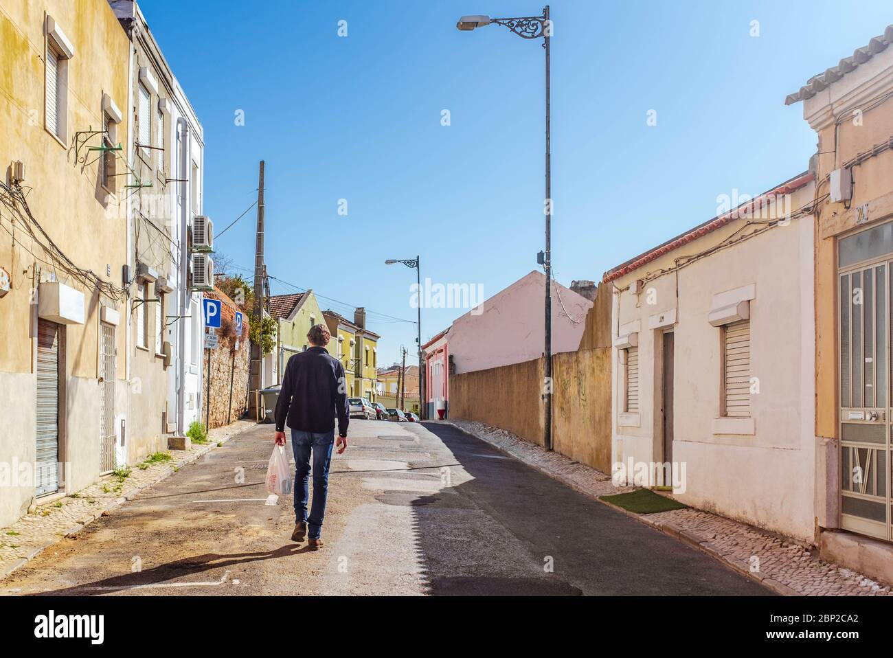 Homme avec sac de shopping en plastique qui se promette dans la rue à Lisbonne. Banque D'Images
