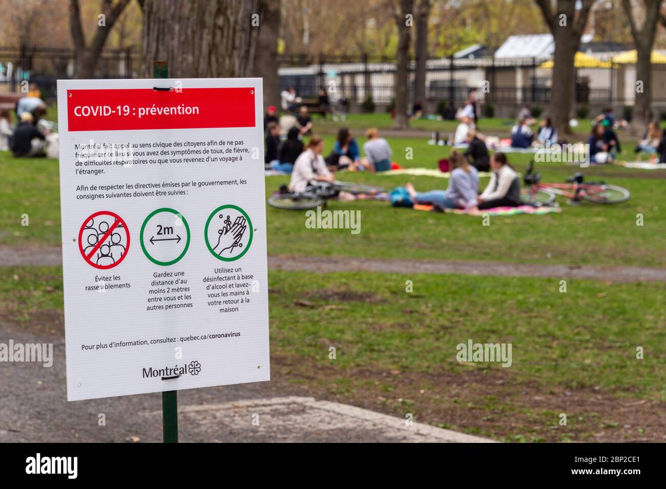Montréal, CA - 16 mai 2020 : panneau montrant les lignes directrices de sécurité Covid-19 que beaucoup de gens se rassemblent dans le parc Lafontaine Banque D'Images