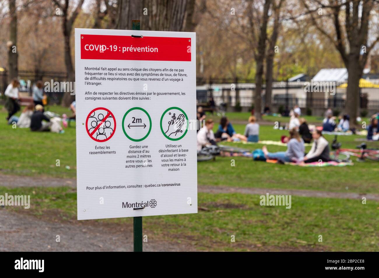 Montréal, CA - 16 mai 2020 : affiche montrant les lignes directrices de sécurité Covid-19 que de nombreuses personnes se rassemblent dans le parc Laurier Banque D'Images