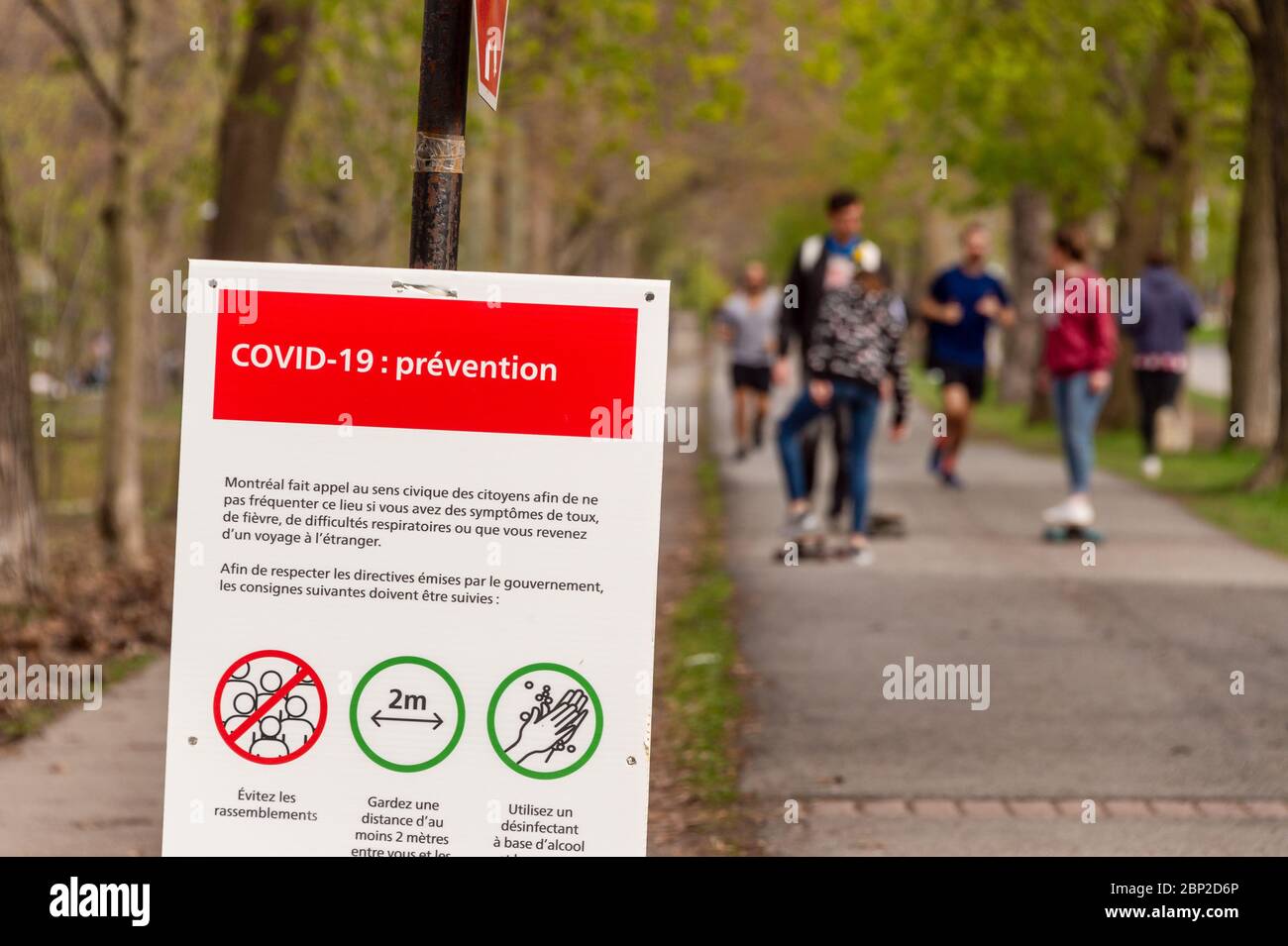 Montréal, CA - 16 mai 2020 : affiche montrant les lignes directrices de sécurité Covid-19 que de nombreuses personnes se rassemblent dans le parc Laurier Banque D'Images