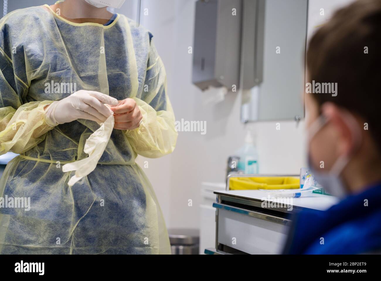 Infirmière mettant des gants avant un écouvillon nasal, dépistage de Covid 19 sur un enfant, Centre médical Cosem Mirosmenil, Paris Banque D'Images