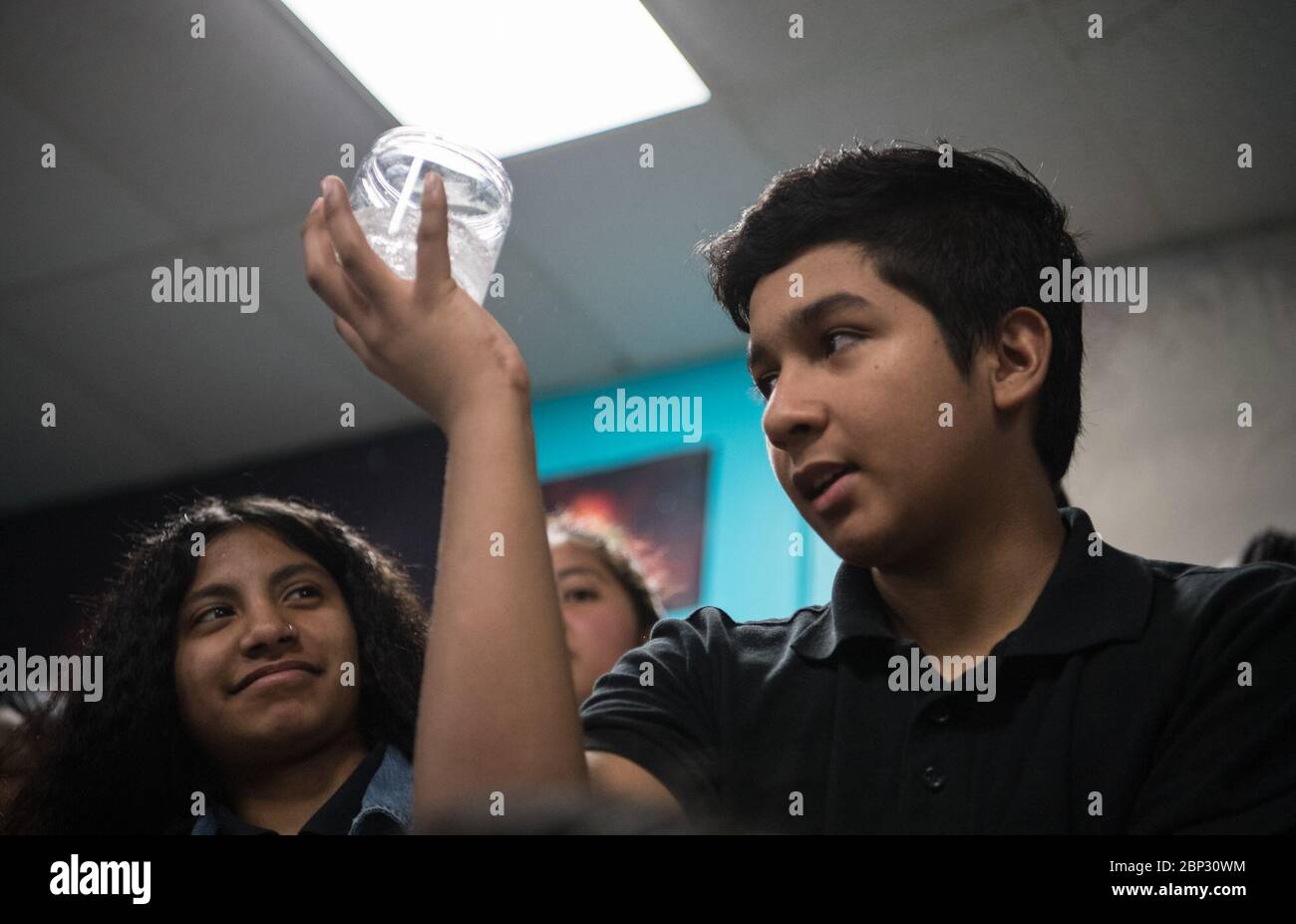 L'astronaute Ricky Arnold au centre Challenger UN étudiant tient un verre d'eau avec une patte Alka-Seltzer tout en effectuant une expérience sur l'effervescence, le vendredi 3 mai 2019 au centre Challenger de Lanham, MD. L'astronaute de la NASA Ricky Arnold les a aidés à mener l'expérience qu'il a également menée pendant sa mission de 197 jours à bord de la Station spatiale internationale (ISS) pendant les expéditions 55/56. Banque D'Images