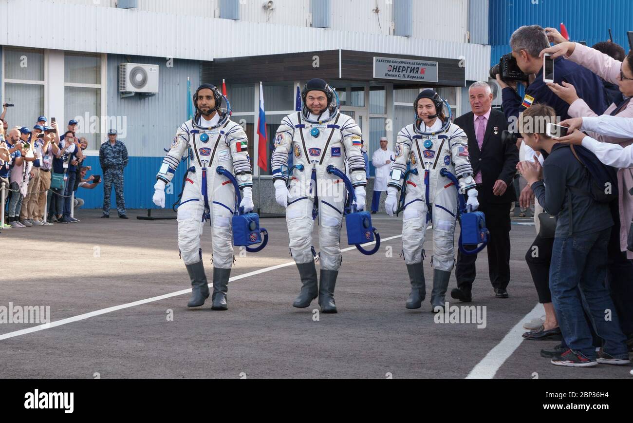 Expédition 61 Preflight participant à l'escoupage Hazzaa Ali Almansoori des Émirats arabes Unis, à gauche, membres de l'équipe d'expédition Oleg Skripochka de Roscosmos, et Jessica Meir de la NASA, à droite, quittent le bâtiment 254 et se dirigent vers leur lancement à bord du vaisseau spatial Soyuz TM-15, le mercredi 25 septembre 2019 au Cosmodrome de Baikonour au Kazakhstan. Meir, Skripochka et Almansoori seront lancés du Cosmodrome de Baikonour à la Station spatiale internationale. Banque D'Images